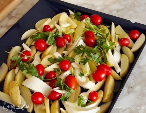 Три зубчика чеснока почистить и крупно порезать, затем посыпать овощи измельченным чесноком и порванной руками петрушкой.