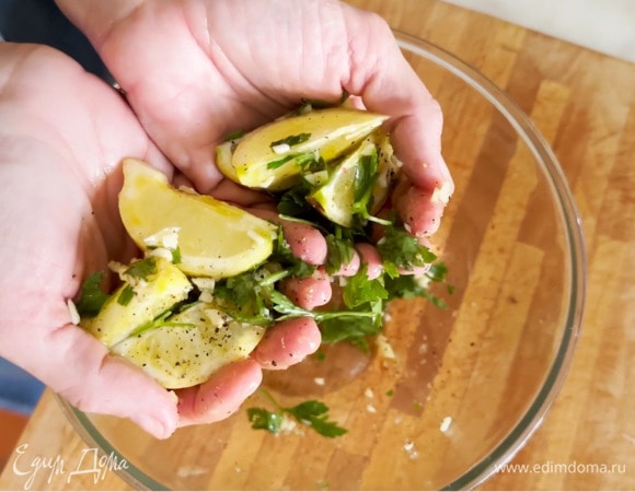 Приготовить начинку: лимон нарезать дольками, чеснок почистить и мелко порубить, выложить все в глубокую миску, полить оливковым маслом, посолить, поперчить, посыпать порванной руками петрушкой и перемешать.