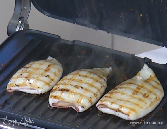 Кальмаров полить оливковым маслом, посолить, поперчить и запекать на гриле до появления румяных полосок с двух сторон.