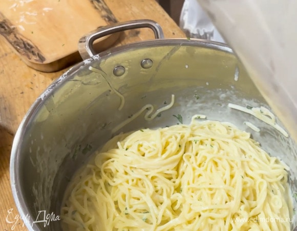 В отваренную лапшу добавить сырный соус, петрушку, влить еще немного воды, в которой варились макароны, и все перемешать.