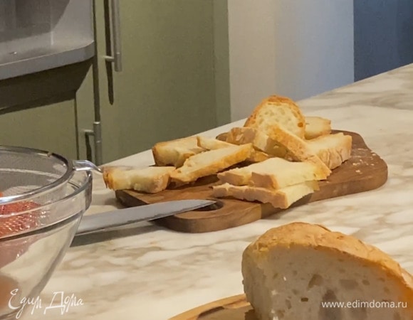 Хлеб нарезать ломтиками, уложить на застеленный бумагой для выпечки противень и запекать в разогретой духовке до появления румяной корочки.