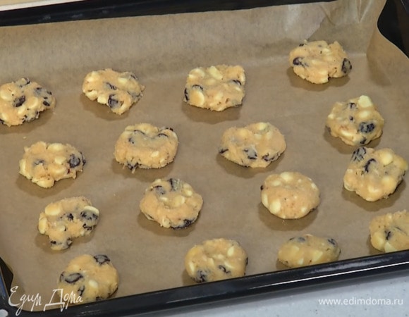 Из охлажденного теста скатать небольшие шарики, выложить на выстеленный бумагой для выпечки противень и слегка прижать их.