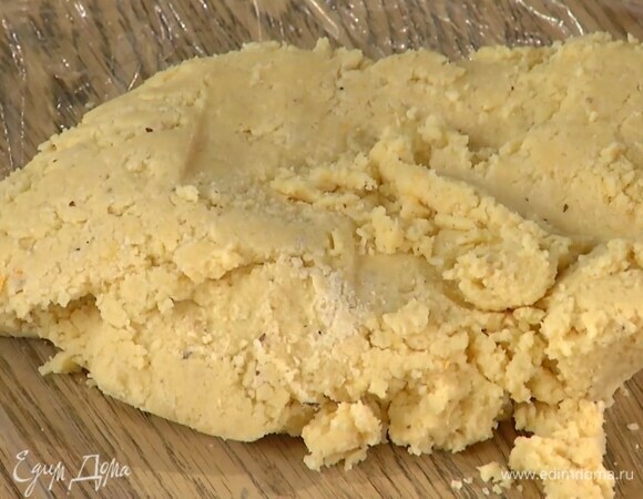 Предварительно размягченное сливочное масло взбить миксером вместе с сахаром в однородную светлую массу, добавить цедру, ванильный экстракт и, продолжая взбивать, по одному ввести желтки. Небольшими порциями всыпать половину муки с орехами, каждый раз вымешивая, затем добавить оставшуюся муку и вымесить тесто руками.