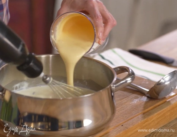 Сахар с желтками взбить блендером с насадкой-венчиком. Продолжая взбивать, тонкой струйкой влить половину горячего молока, затем желтково-молочную смесь перелить в кастрюлю с оставшимся молоком и перемешать.