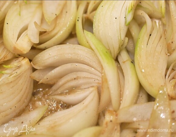 Лук почистить, нарезать вдоль дольками и выложить в кастрюлю, где жарились ножки, добавить все оставшееся масло и закарамелизировать лук на маленьком огне.