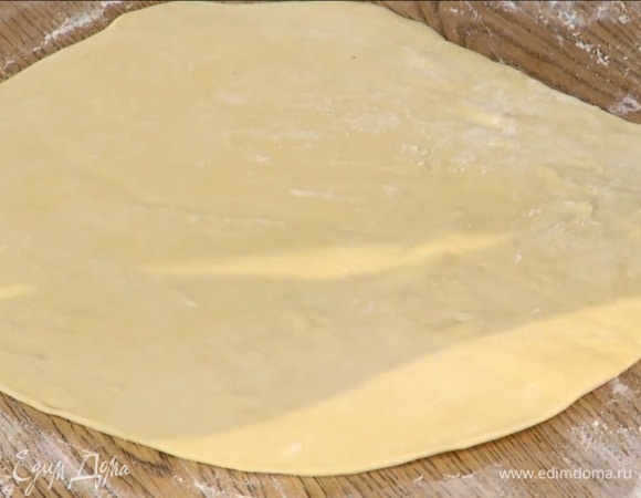 Посыпать рабочую поверхность мукой и раскатать тесто в тонкий пласт.
