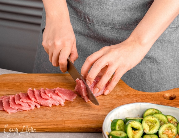 Удалите со свиной вырезки жилки и нарежьте тонкими слайсами.