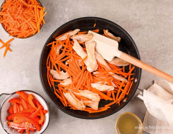 Добавьте к курице нарезанную морковь и обжаривайте еще 3–5 минут. Всыпьте болгарский перец и прогрейте 2–3 минуты.