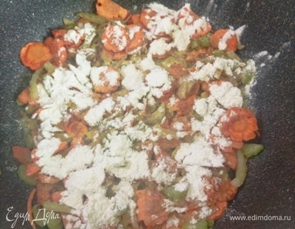 В этой же кастрюле в течение 5 минут обжарьте морковь, сельдерей и лук. Посыпьте мукой и перемешайте.