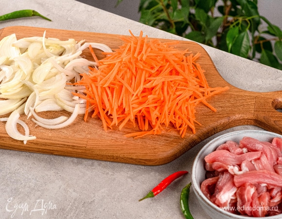 Соломкой нарежьте лук, морковь и свинину. Обжарьте ингредиенты в таком порядке: сначала лук до прозрачности, затем морковь. В отдельной сковороде сделайте глазунью.