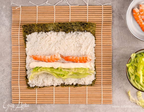 Выложите в ряд начинку: сначала листья салата, затем творожный сыр и креветки.