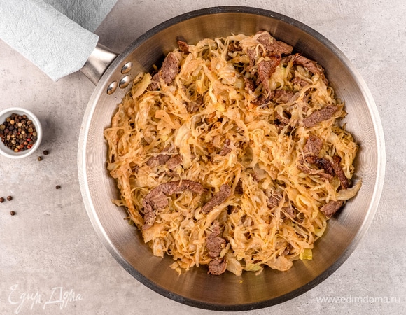 Нарежьте говядину тонкой соломкой. Обжарьте ее на разогретой сковороде 3–5 минут. Добавьте к говядине нашинкованную капусту. Поперчите, посолите смесь, потушите на среднем огне 10 минут.