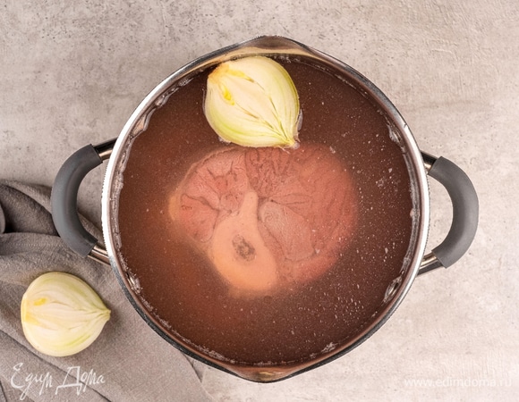 После закипания добавьте в бульон 1/2 белого репчатого лука. Накройте крышкой, уменьшите огонь до небольшого и оставьте на 1,5 часа.