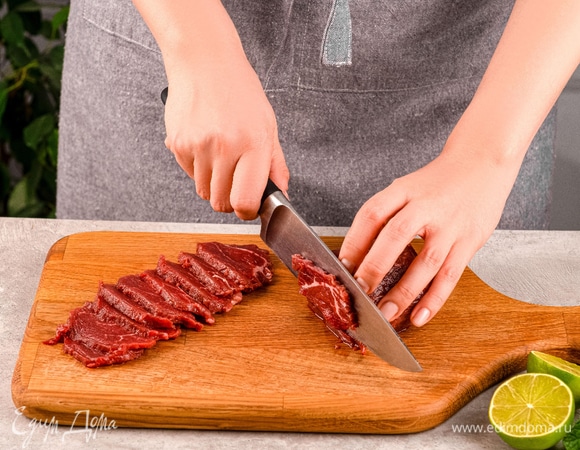 Говяжью вырезку нарежьте на тончайшие слайсы и отварите до полуготовности. Затем выньте мясо.