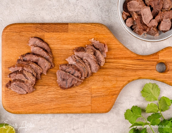 Голяшки из бульона нарежьте тонкими слайсами и положите в отдельную емкость.