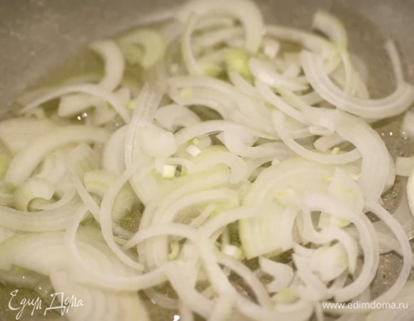 Лук почистить, нарезать тонкими полукольцами и обжарить на разогретом в сковороде оливковом масле с чесноком.
