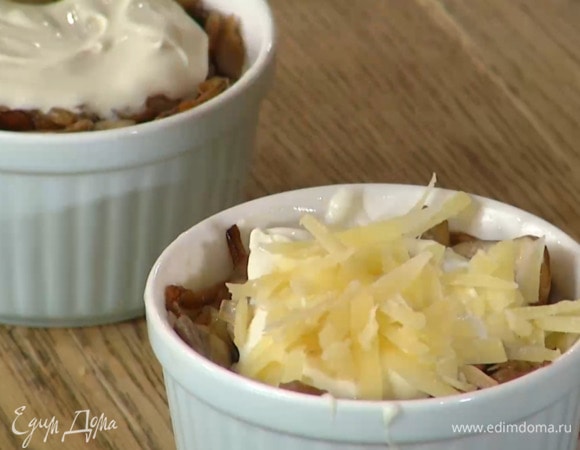 Небольшие керамические формочки смазать сливочным маслом, слегка посыпать сыром, разложить куриное мясо, добавить в каждую форму по 1 ст. ложке соуса, грибы с луком и сверху по 1 ч. ложке сметаны. Посыпать натертым сыром.