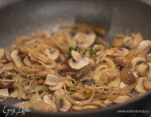 Шампиньоны нарезать пластинками и выложить к луку, добавить 2 веточки тимьяна, посолить и жарить на сильном огне, постоянно помешивая, затем уменьшить огонь и жарить еще минут 10, не закрывая крышкой.