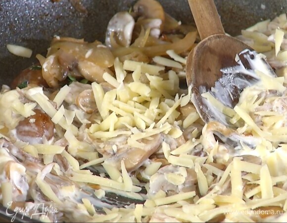 Из готовых грибов удалить веточки тимьяна, добавить свежие листья оставшегося тимьяна, сметану, горсть натертого сыра и перемешать.