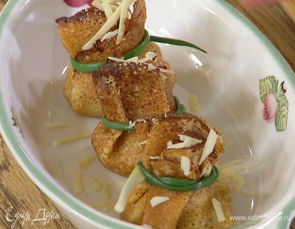 Выложить блины в жаропрочную керамическую форму, посыпать сверху оставшимся сыром и запекать под разогретым грилем несколько минут.