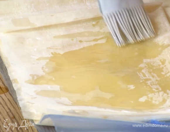 Листы фило смазать с одной стороны оливковым маслом, свернуть пополам, смазать верхнюю часть маслом, затем свернуть еще раз и смазать сверху.