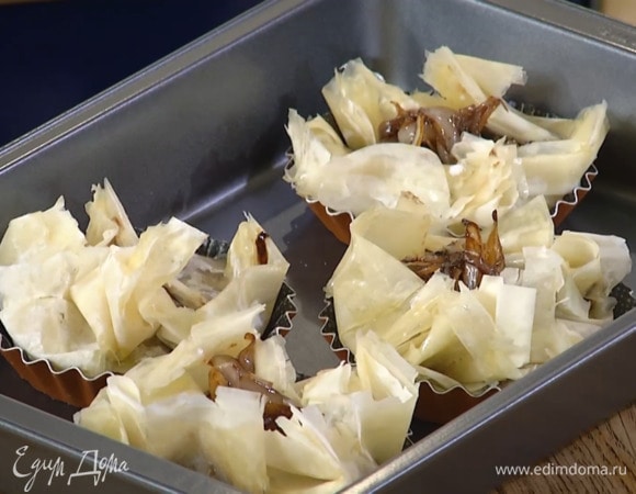 Поместить тарталетки на противень и выпекать в разогретой духовке 10–12 минут.