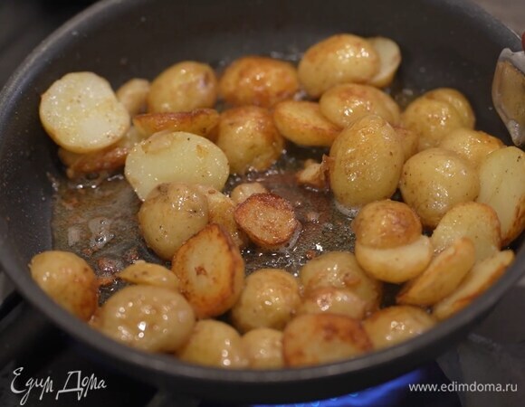 Картофель отварить в мундире до готовности, затем разрезать пополам, выложить в сковороду с разогретым сливочным и оливковым маслом, слегка посолить, поперчить и обжаривать до появления золотистой корочки.