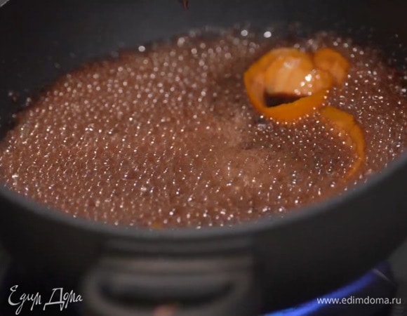 В тяжелый сотейник влить вино, всыпать мусковадо и перемешать, затем добавить кардамон и цедру, уварить все на треть и выключить огонь.