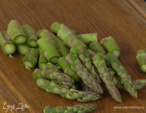 Спаржу, отломив грубые кончики, разрезать на несколько частей, добавить в кастрюлю с овощами и бланшировать несколько минут, затем откинуть все на дуршлаг.
