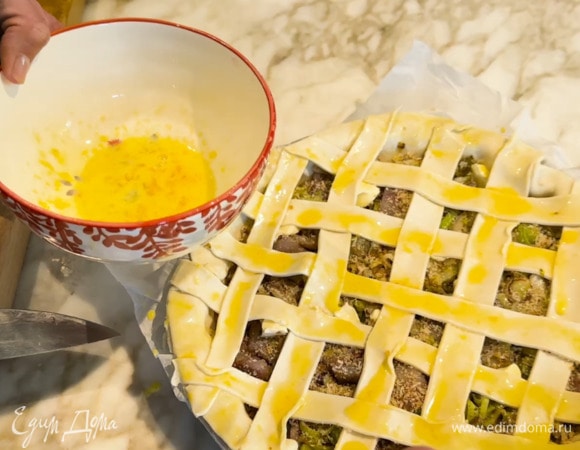 Второй пласт теста нарезать полосками, уложить решеткой на пирог и смазать желтком, перемешанным со щепоткой соли.