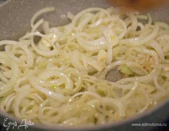 Лук почистить, нарезать тонкими полукольцами и обжарить на разогретом в тяжелой сковороде оливковом и сливочном масле.