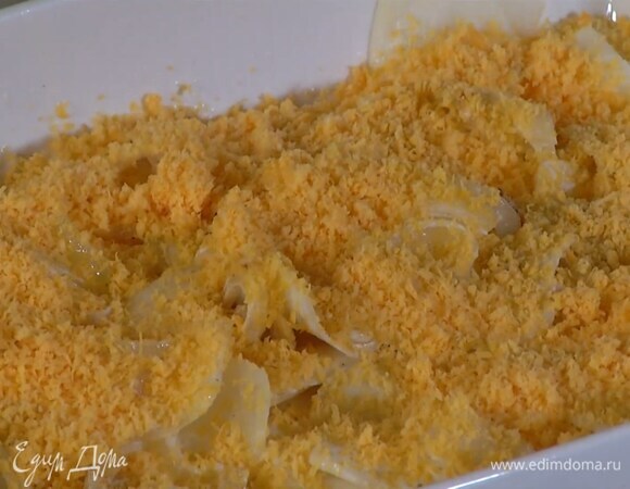 Дно глубокой керамической формы посыпать натертым сыром и уложить три слоя картофеля, каждый посолить, поперчить и посыпать чеддером, на верхний слой выложить половину сливочно-луковой массы и посыпать сыром.