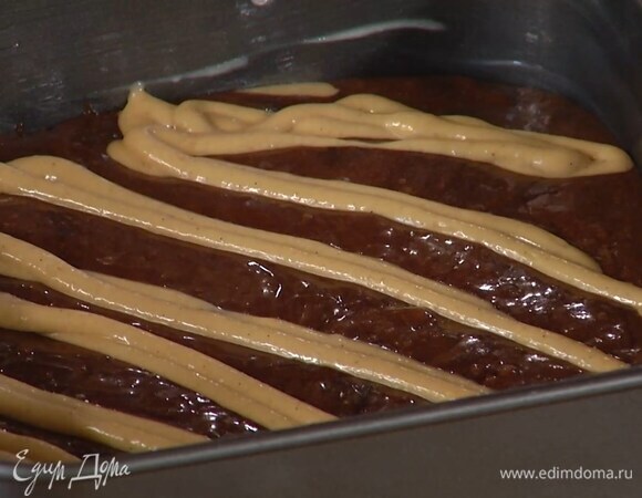 Арахисовую массу выложить в кондитерский мешок и зигзагами выдавить половину на тесто, затем выложить оставшееся шоколадное тесто и сверху также выдавить арахисовую массу.