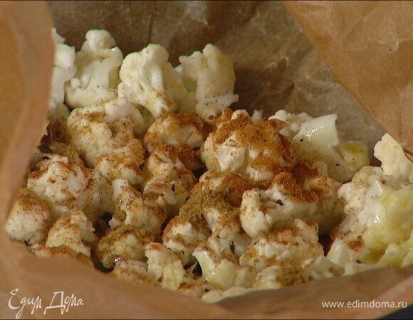 Цветную капусту разобрать на самые мелкие соцветия, выложить в небольшой глубокий противень, выстеленный бумагой для выпечки, слегка посолить, поперчить, слегка сбрызнуть оливковым маслом, посыпать сладкой паприкой и зирой, все перемешать и запекать в разогретой духовке 15–20 минут.