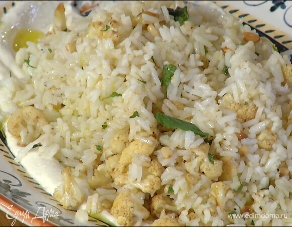 Рис перемешать с цветной капустой, кедровыми орехами и мятой, выложить все на тарелку с йогуртом, полить оставшимся оливковым маслом и украсить отложенными листьями мяты.