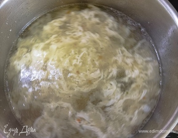 Влейте бульон (мясной, овощной или порошковый). Доведите до кипения и убавьте нагрев до среднего. Яйцо слегка взбейте вилкой и тонкой струйкой влейте в бульон, помешивая его. Добавьте мелкие макароны и проварите минут 5–7.