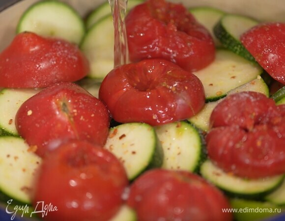 Еще раз перевернуть бедрышки, добавить томатную пасту, разложить сверху баклажаны, посолить, посыпать чили, влить немного растительного масла, сверху разложить сладкий перец, цукини и помидоры срезами вниз, посолить, посыпать чили и залить горячим бульоном.