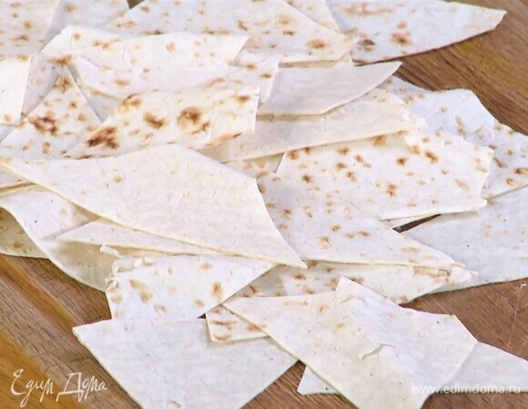 Лаваш нарезать небольшими треугольниками, выложить на противень и подсушить в разогретой духовке, затем слегка сбрызнуть оливковым маслом.