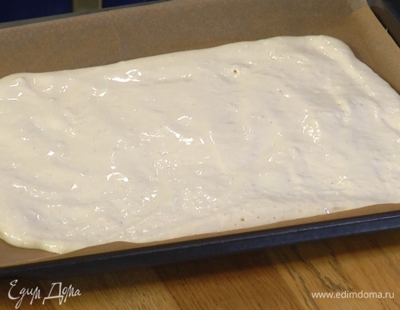 Противень выстелить бумагой для выпечки, вылить тесто и разровнять его в прямоугольник по всему периметру.