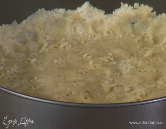 Дно разъемной формы выстелить бумагой для выпечки и выложить тесто, сформировав тонкий корж с бортиками, затем часто наколоть его вилкой, накрыть бумагой для выпечки и всыпать любые бобовые для груза.