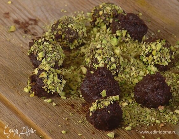 Влажными руками сформировать из шоколадной массы шарики и обвалять в измельченных фисташках.