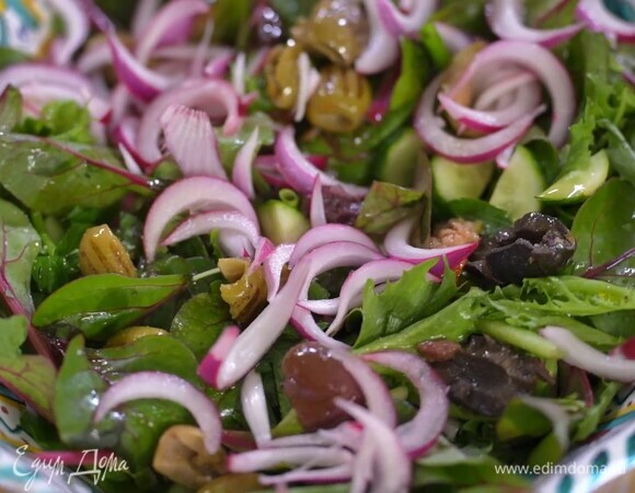 Приготовить салат: в глубокую миску выложить салатные листья, огурцы, помидоры, нарезанную зелень, порванные руками оливки, все посолить, полить оливковым маслом, сверху разложить замаринованный красный лук.