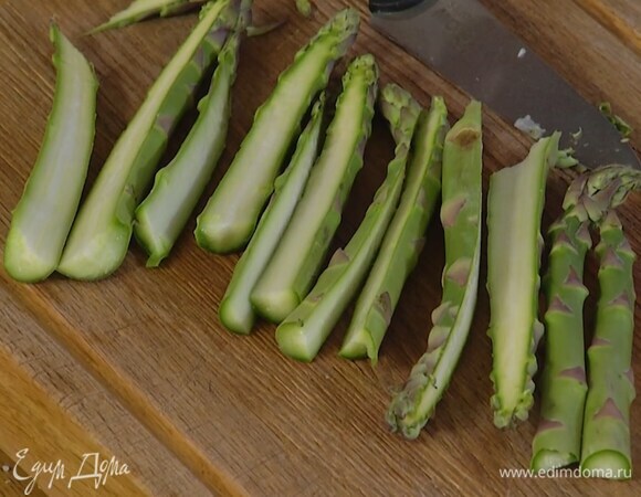 Спаржу, удалив грубые черенки, разрезать вдоль пополам.