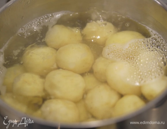 Картошку, не очищая, отварить целиком, затем, слив воду, выложить в миску.