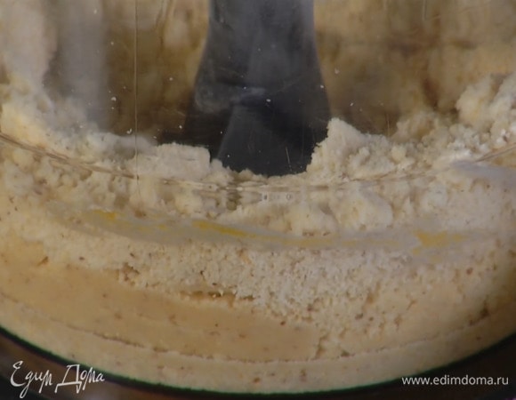 Нарезать кубиками 120 г предварительно охлажденного сливочного масла, выложить в чашу блендера, всыпать муку, 20 г миндаля и соль, добавить желток и все взбить.