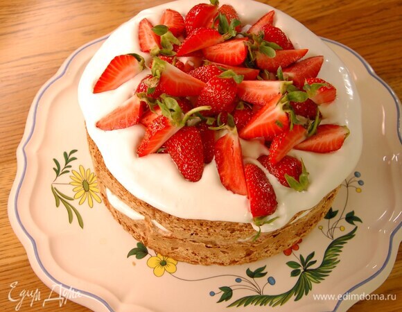 Клубнику с плодоножками разрезать на 4 части и украсить пирог.