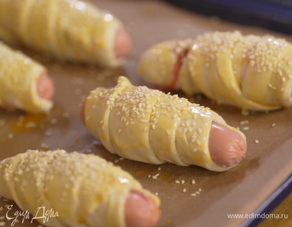 Желток посолить, влить капельку воды, перемешать и смазать тесто, сверху посыпать кунжутом.