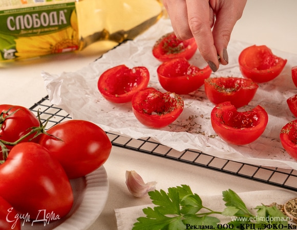 Застелите противень пергаментом, разложите томаты срезом вверх. Посыпьте солью и сухими травами.