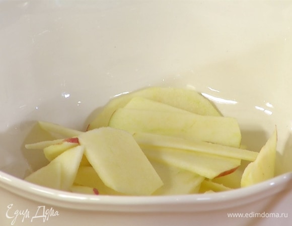 Яблоко очистить от кожуры и, удалив сердцевину, нарезать небольшими ломтиками, затем выложить в салатник и полить оставшимся лимонным соком.