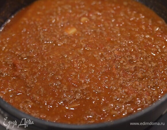 Консервированные томаты добавить к фаршу и томить соус на медленном огне 15‒20 минут, пока он не загустеет.